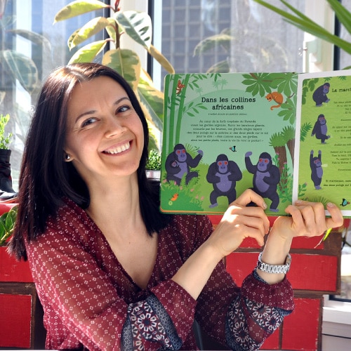 Femme souriante tenant une livre pour enfant