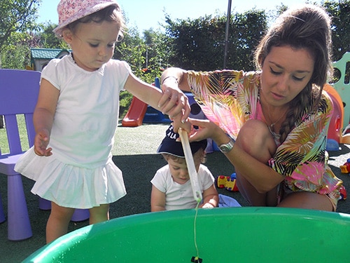 Deux enfants jouent avec une jeune femme